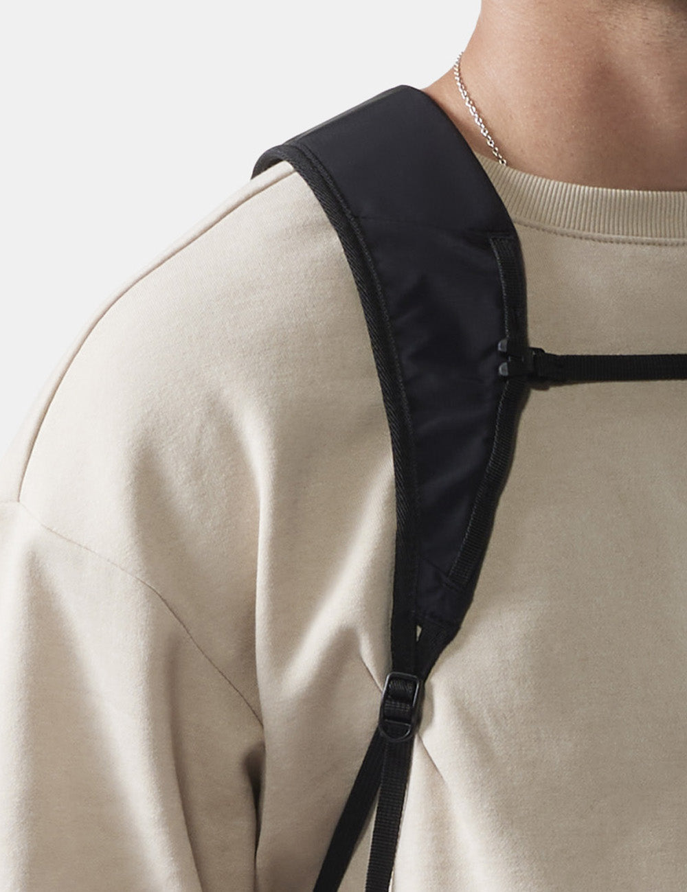 close up view of black backpack strap on a person's shoulder