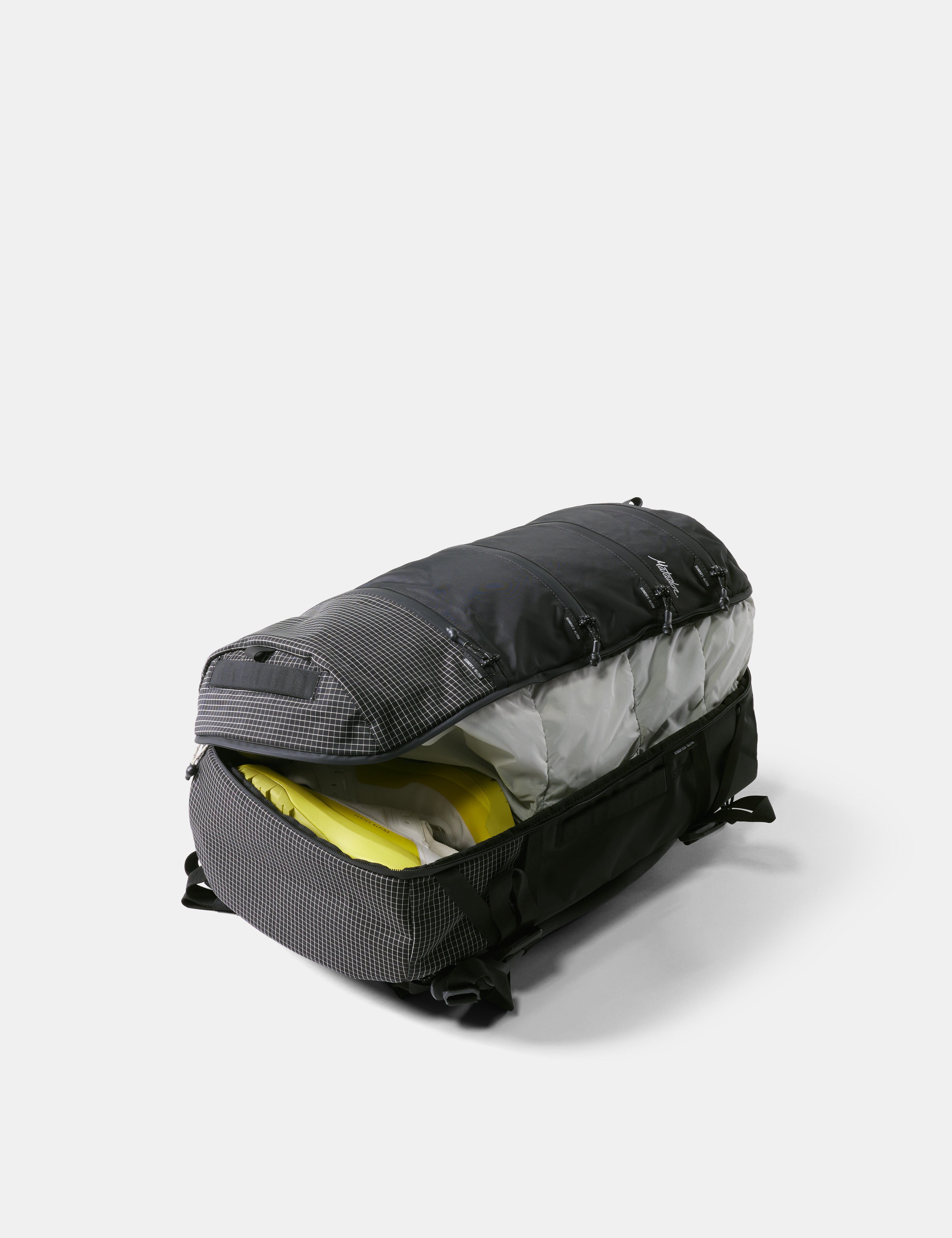 Black duffel bag with yellow interior contents on a white background